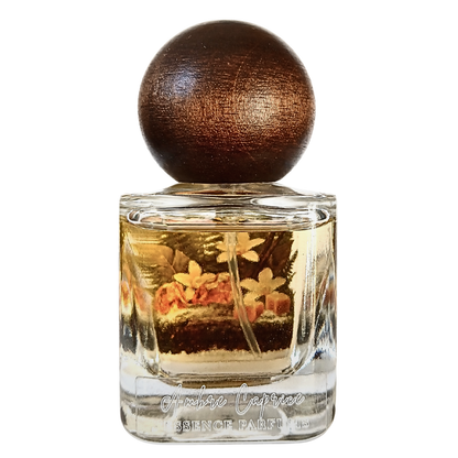 Artisanal 30ml Ambre Caprice perfume bottle with a spherical wooden cap and a botanical terrarium style label. J'essence Parfums niche gourmand fragrance hand poured in NZ.