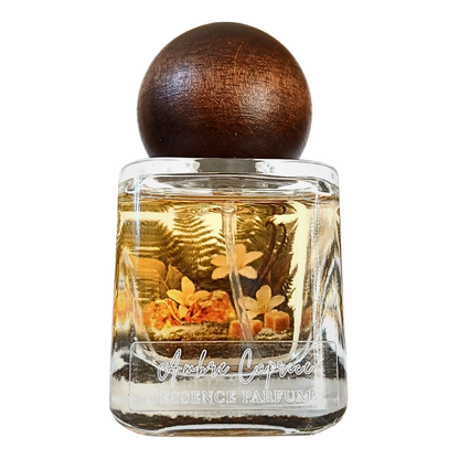 Artisanal 30ml Ambre Caprice perfume bottle with a spherical wooden cap and a botanical terrarium style label. J'essence Parfums niche gourmand fragrance hand poured in NZ.