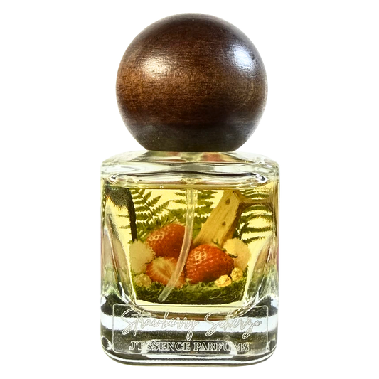 Artisanal 30ml Strawberry Scherzo perfume bottle with a spherical wooden cap and a botanical terrarium style label. J'essence Parfums niche gourmand fragrance hand poured in NZ.